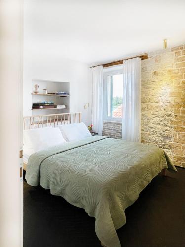 a bedroom with a large bed with a brick wall at Golden View - Old town apartment in Rovinj