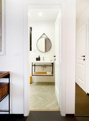 a white bathroom with a sink and a mirror at Golden View - Old town apartment in Rovinj