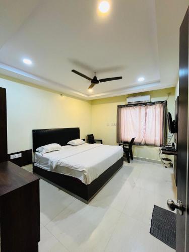 a bedroom with a bed and a ceiling fan at The Royal Comforts in Visakhapatnam