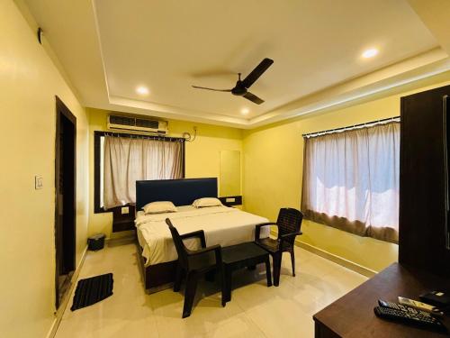 a bedroom with a bed and a table and chairs at The Royal Comforts in Visakhapatnam