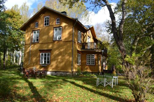 a large wooden house in the middle of a yard at Kirjakkalan Ruukkikylä in Teijo
