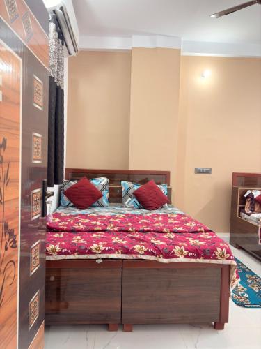 a bedroom with a bed with red pillows at Shree Rameshth Homestay in Ayodhya