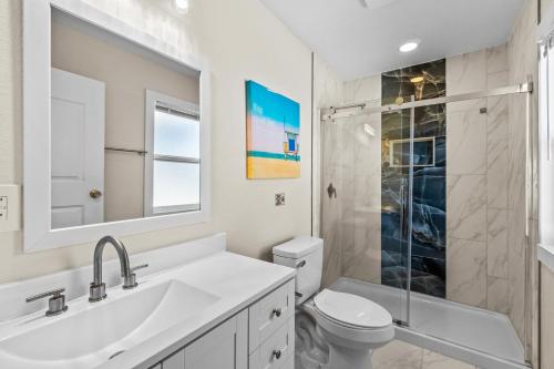 a bathroom with a sink and a toilet and a shower at Beachfront Villa Royale OBX in Avon