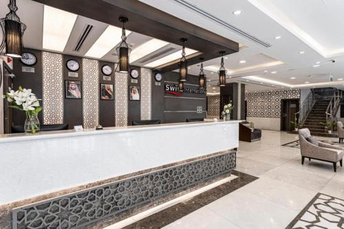 a bar in a hotel lobby with clocks on the wall at Taba Al Salam in Medina