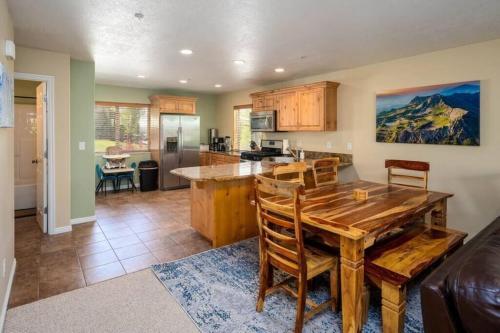 a kitchen and living room with a wooden table and chairs at Ski Paradise MH 303 Near Powder Mtn Hot Tub in Eden