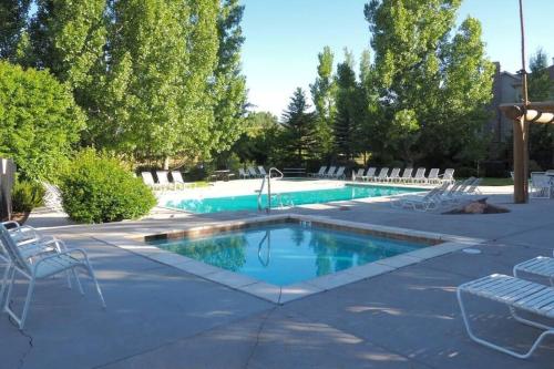 a swimming pool with chairs next to at Eden Mtn Retreat MH207 Near Powder Mtn Hot Tub in Eden