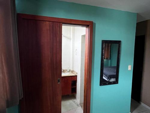 a bathroom with a sink and a mirror on a wall at Kitnet Aurora in Miguel Pereira