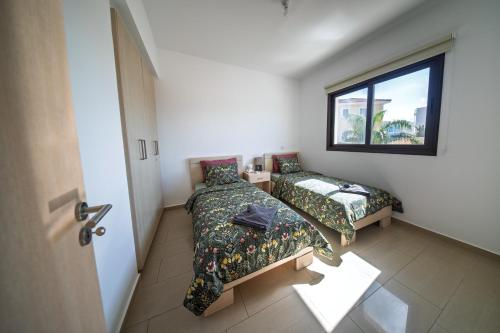 a small room with two beds and a window at Elia House In Kapparis in Paralimni