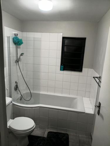 a bathroom with a tub and a toilet and a window at Coastal Guest House with Free Parking and Braai Area in Cape Town