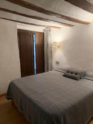 a bedroom with a bed with a blue blanket at El Encantodemora in Mora de Rubielos