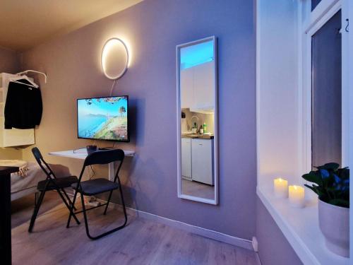 a room with a mirror and a desk with a computer at Cozy Central Studio by the Bus Station in Bergen