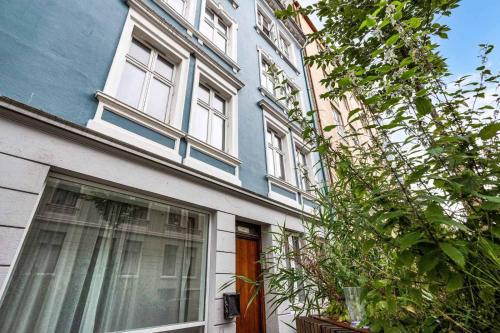 a blue and white house with a window at Cozy Central Studio by the Bus Station in Bergen