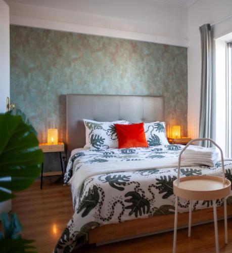 ein Schlafzimmer mit einem Bett und zwei Tischen mit Lampen in der Unterkunft Just4uApartment 2 - Near Lisbon & Beach - With AC in Almada