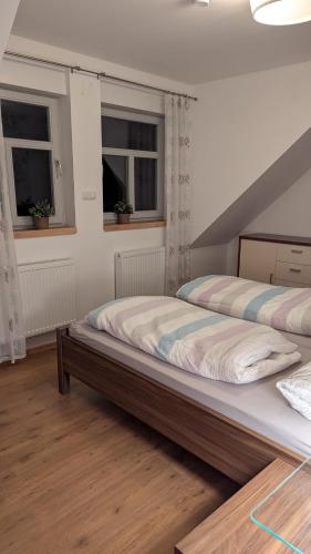 two beds in a bedroom with two windows at Lohbachhof in Wolfhagen