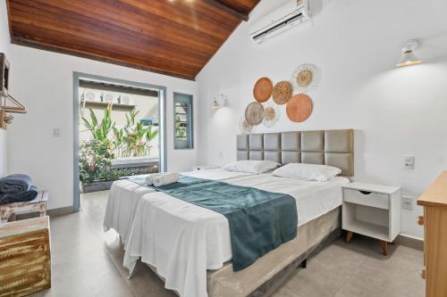 a bedroom with a large bed and a window at A CASA DA PRAIA DO FORTE in Praia do Forte