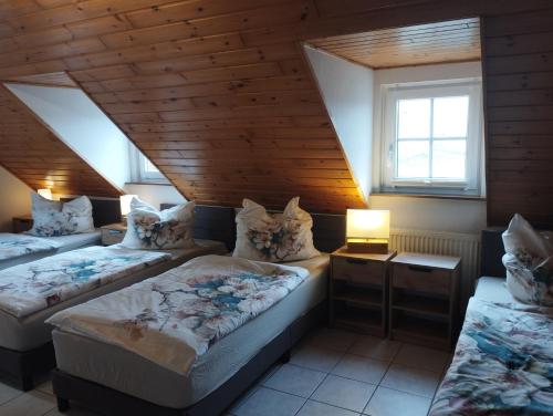 a bedroom with two beds and a wooden ceiling at Ferienhaus Schilz in Plütscheid