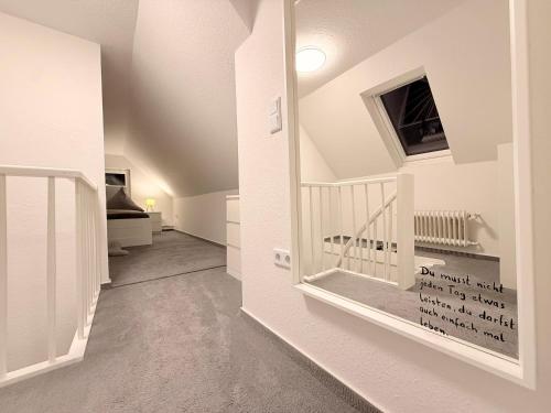 a hallway with white walls and a staircase in a house at Ferienhaus Teenös in Hinte