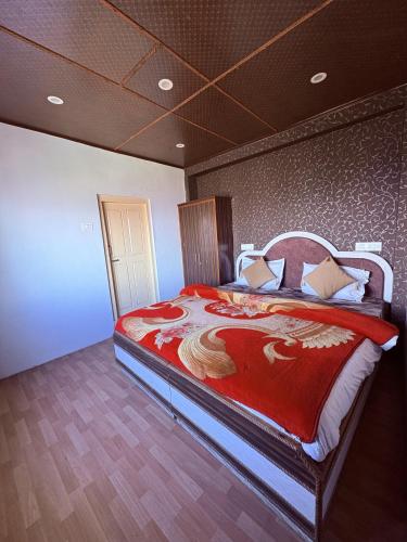 a bedroom with a large bed with a red blanket at Nature Nook's Kufri in Kūfrī