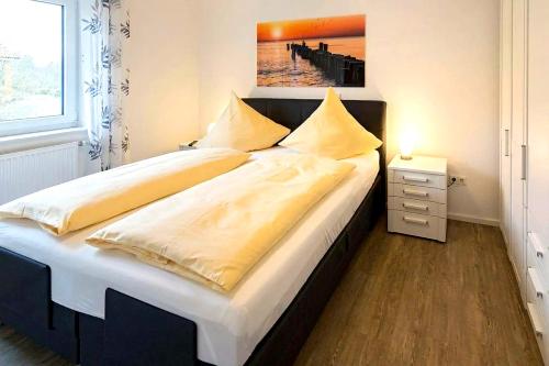 a bedroom with a large bed with white sheets at Tillmanns Stadtlounge in Norden