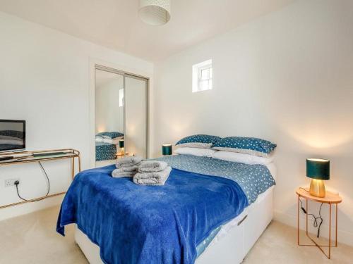 a bedroom with a blue bed with towels on it at One The Loan in Inverness
