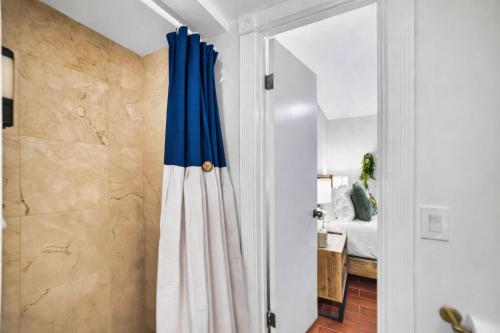 a bathroom with a blue curtain next to a bedroom at Home in Miami in Lindgren Acres