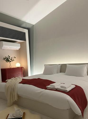 a bedroom with a large white bed with red blanket at Mare di Miyajima マーレ ディ ミヤジマ in Miyajima