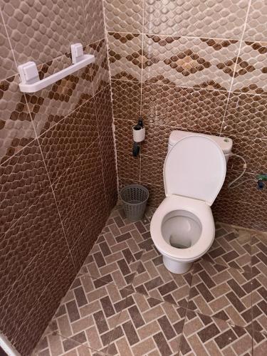 a bathroom with a toilet in a stall at Maison La Baraka Merzouga in Merzouga