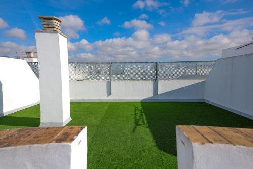 a balcony with white walls and green grass at Charming Apartment with Private Terrace in Sanlúcar de Barrameda