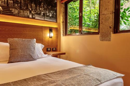 a bedroom with a bed and two windows at Mi Zona Lodging Coyoacán in Mexico City