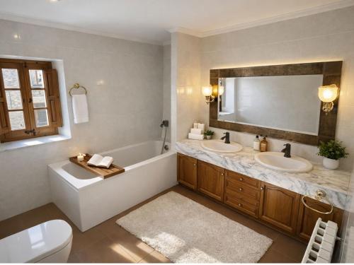 a bathroom with two sinks and a tub and a mirror at Masia Can Cenç in Collsuspina