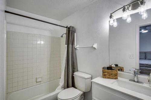 a white bathroom with a toilet and a sink at Sun, Sand & Poolside Relaxation! Ormond Beach Unit in Ormond Beach