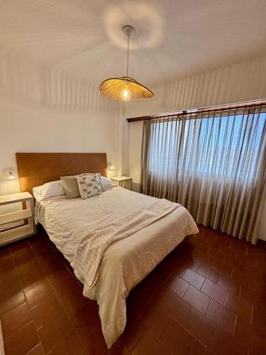 a bedroom with a bed and a large window at Depto Frente Al Mar, Edificio Iskofema II in Miramar