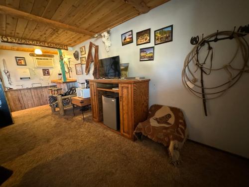a living room with a tv and a chair in a room at Stagecoach 66 Motel by Capital O in Seligman