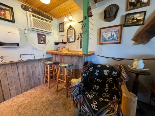 a room with a bar with a couch and stools at Stagecoach 66 Motel by Capital O in Seligman