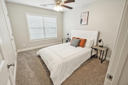 a white bedroom with a bed and a window at Properties by Preston I 2Bd2bth Townhome in Clarksville