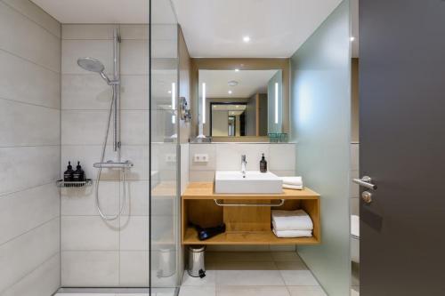 a bathroom with a sink and a shower at Piazza Hotel und Restaurant in Aalen