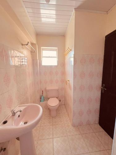 a bathroom with a toilet and a sink at Crystal Luxury Palace in Nairobi