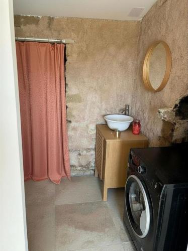 a bathroom with a washing machine and a sink at Bergerie du Riccio avec piscine privée in Cauro
