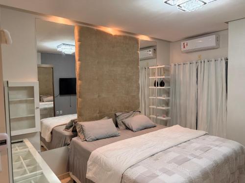 a bedroom with two beds and a mirror at Casa com piscinas paragominas in Paragominas