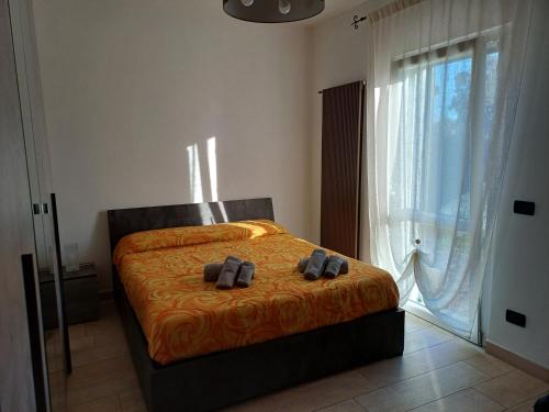 a bedroom with a bed with two shoes on it at Charme rustico con ampio giardino e piscina con due camere in Carrara