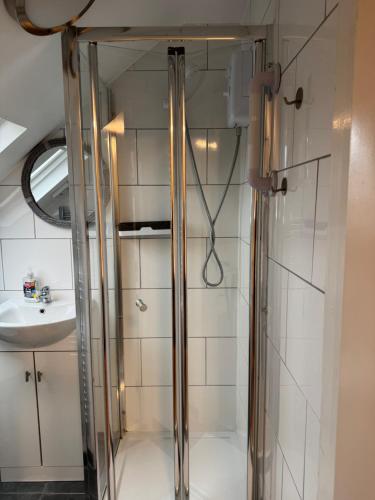 a glass shower in a bathroom with a sink at Kensal Lodge 2 Guest House in London