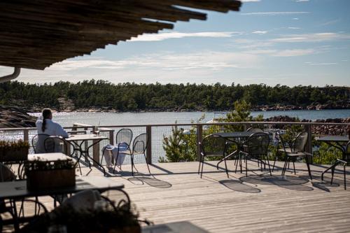 a person sitting at a table on a deck overlooking a lake at HavsVidden Resort in Geta