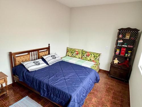 a bedroom with a bed with a blue comforter at Nogueira Home in Passa Quatro