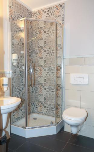 a bathroom with a shower with a toilet and a sink at Karczma Kujawska in Inowrocław