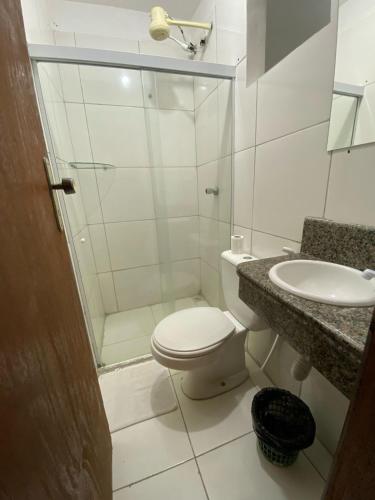 a bathroom with a shower and a toilet and a sink at its hotel in Itapetinga