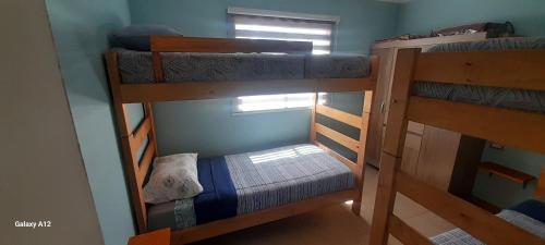 two bunk beds in a room with a window at Quillon cabañas in Quillón