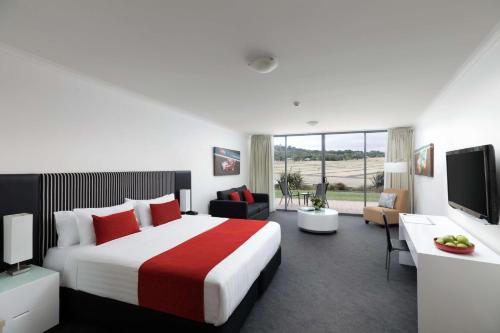 a hotel room with a bed and a television at Rydges Mount Panorama Bathurst in Bathurst