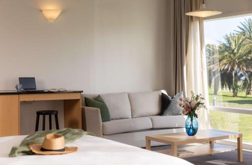 a living room with a couch and a table at Rydges Formosa Auckland Golf Resort in Auckland