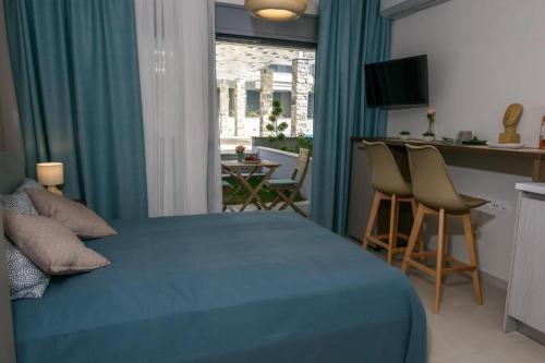 a bedroom with a bed and a kitchen with a table at Studio Apartments Itaka in Nikiti