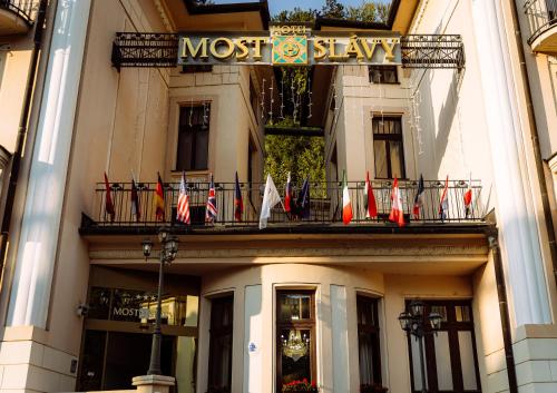 a building with a bunch of flags on a balcony at Hotel Most Slávy in Martinske Hole